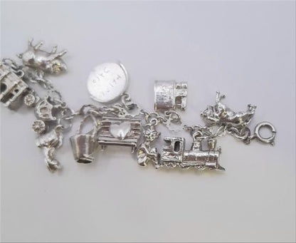 Silver charm bracelet with intricate designs, weighing 45.9g, featuring various charms and a secure clasp.