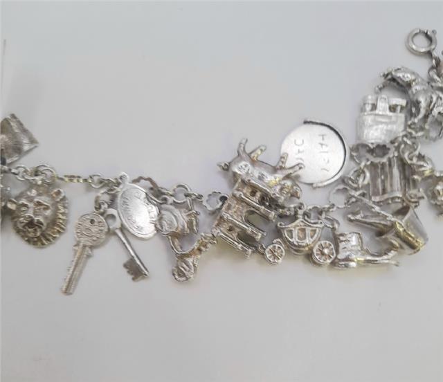 Silver charm bracelet with intricate designs, weighing 45.9g, featuring multiple charms on a sturdy silver chain.