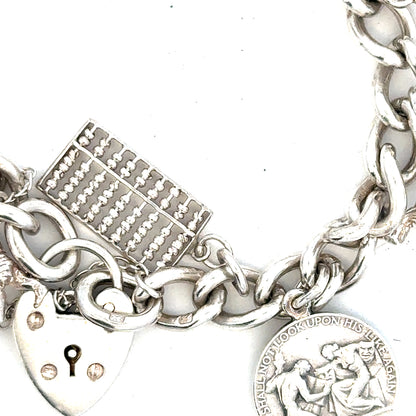 Silver charm bracelet weighing 60.1g with various charms, crafted with detailed links, unbranded jewelry accessory.