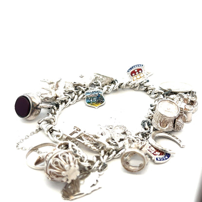 Silver charm bracelet with intricate details, weighing 61g, featuring various decorative charms and a secure clasp.