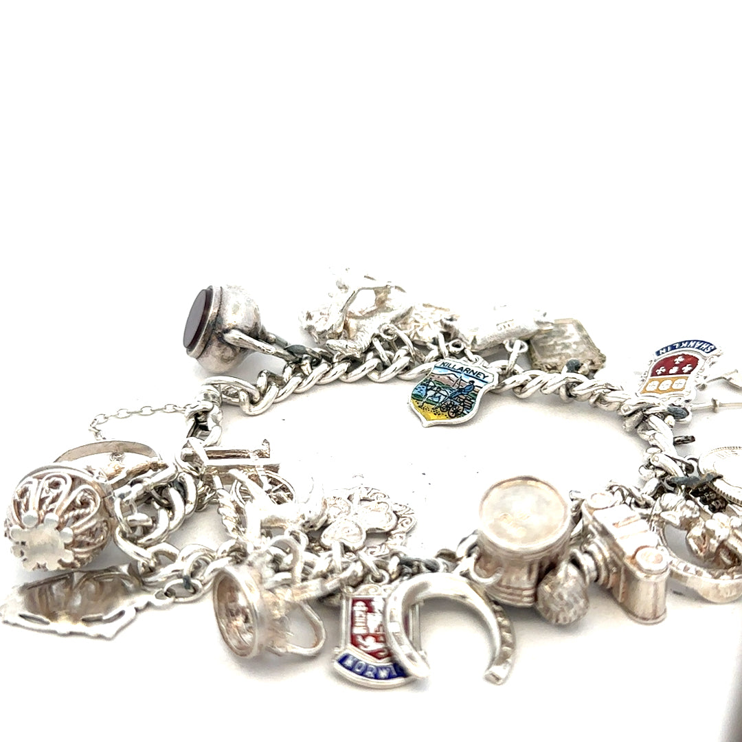Silver charm bracelet with intricate designs, weighs 61g, featuring various decorative charms and linked chain style.