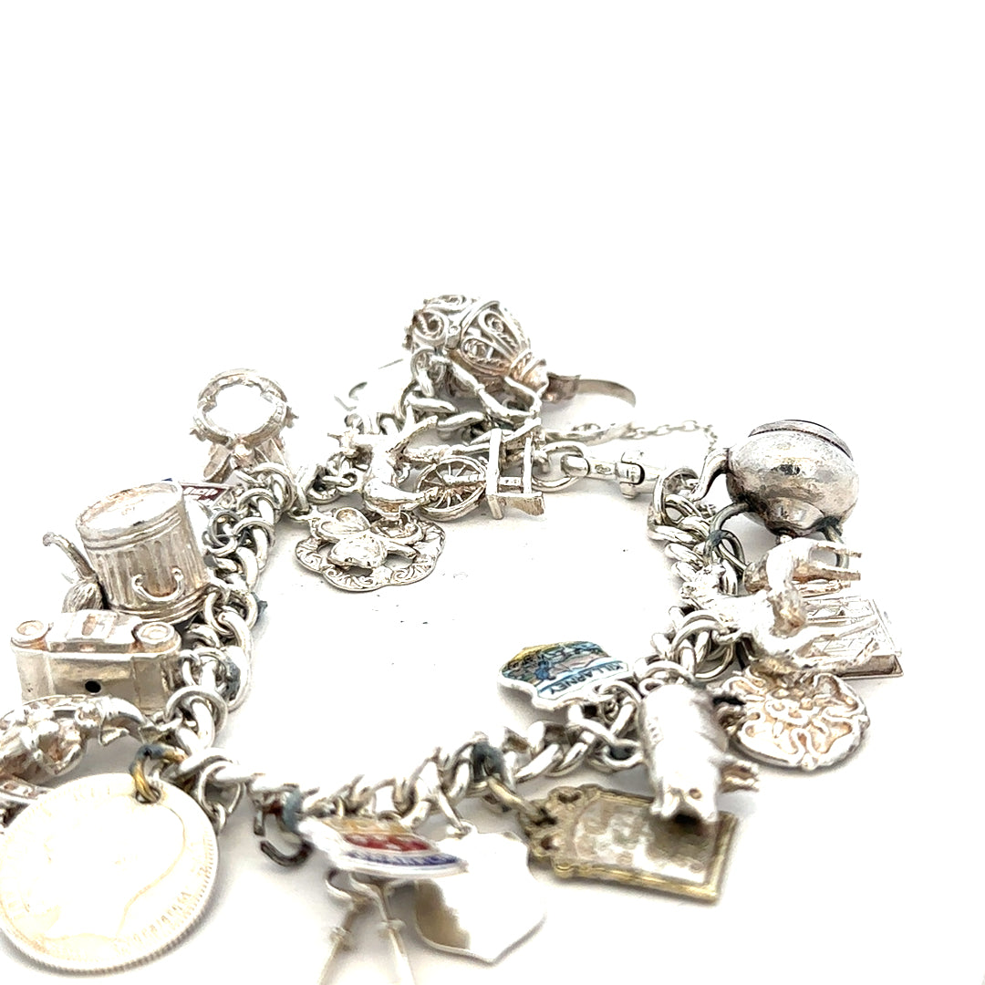 Silver charm bracelet weighing 61g with various charms, featuring a sleek and elegant design, perfect for stylish accessories.