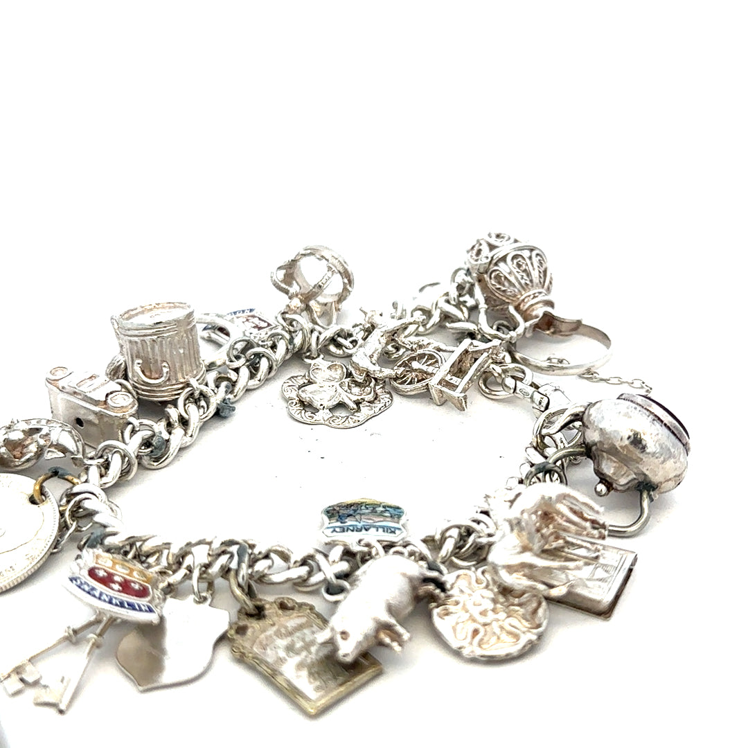 Silver charm bracelet weighing 61g with various dangling charms, unbranded jewelry accessory on a plain background.