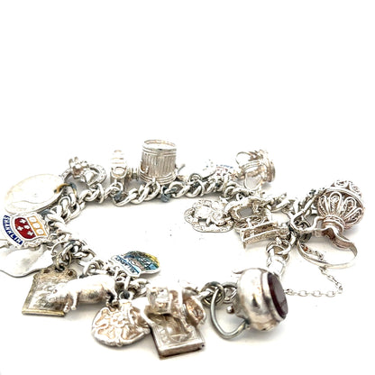 Silver charm bracelet weighing 61g with various decorative charms, unbranded jewelry accessory, close-up view of detailed design.