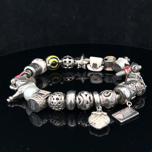 Silver charm bracelet with adjustable length, featuring various decorative charms on a sleek silver chain.