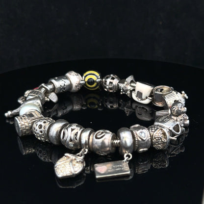 Silver charm bracelet with multiple charms, 64.8 cm length, unbranded, shown on a neutral background.