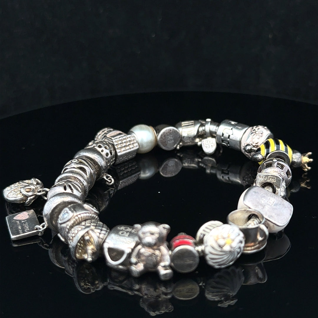 Silver charm bracelet with multiple decorative charms, featuring a 64.8 cm length, unbranded jewelry accessory.