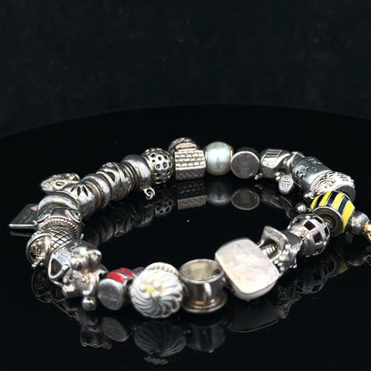 Silver charm bracelet with multiple decorative charms, 64.8 cm length, unbranded jewelry accessory for women.