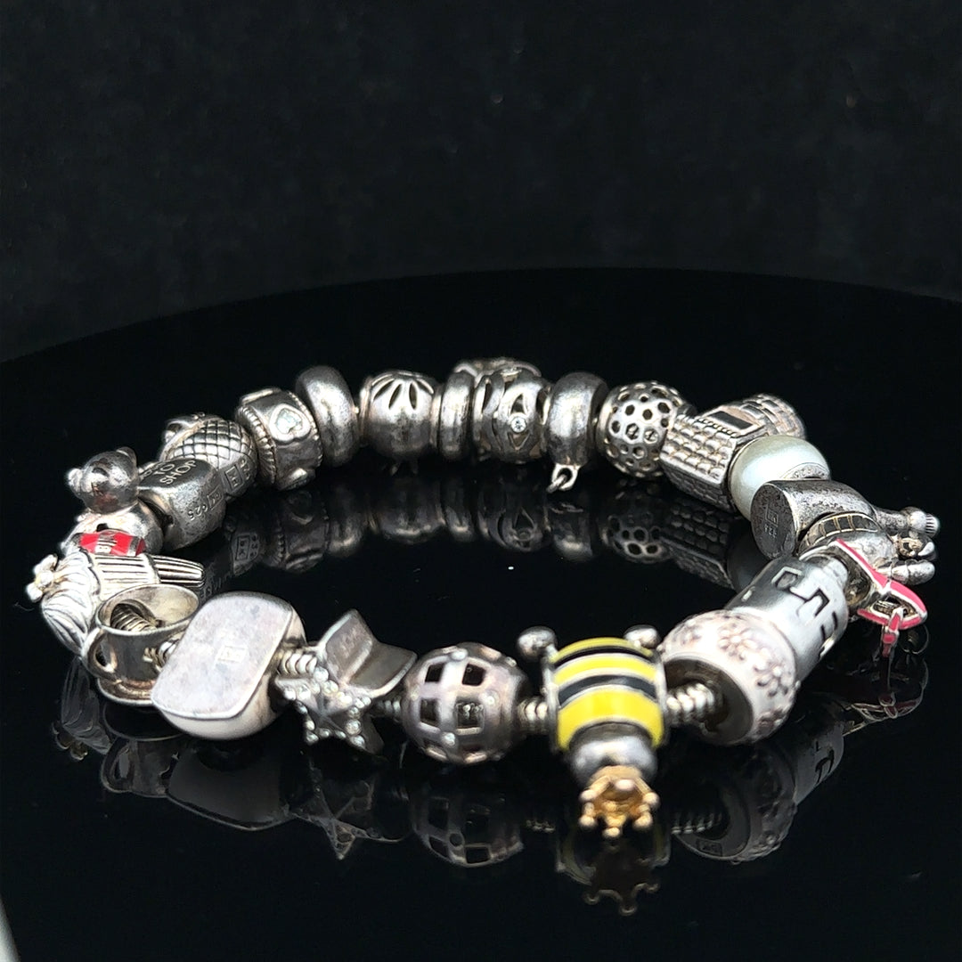 Silver charm bracelet with multiple charms, 64.8cm length, unbranded jewelry accessory, detailed close-up of the bracelet.