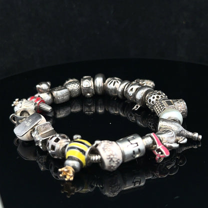 Silver charm bracelet with multiple decorative charms, size 64.8, unbranded jewelry accessory for stylish wrist decoration.