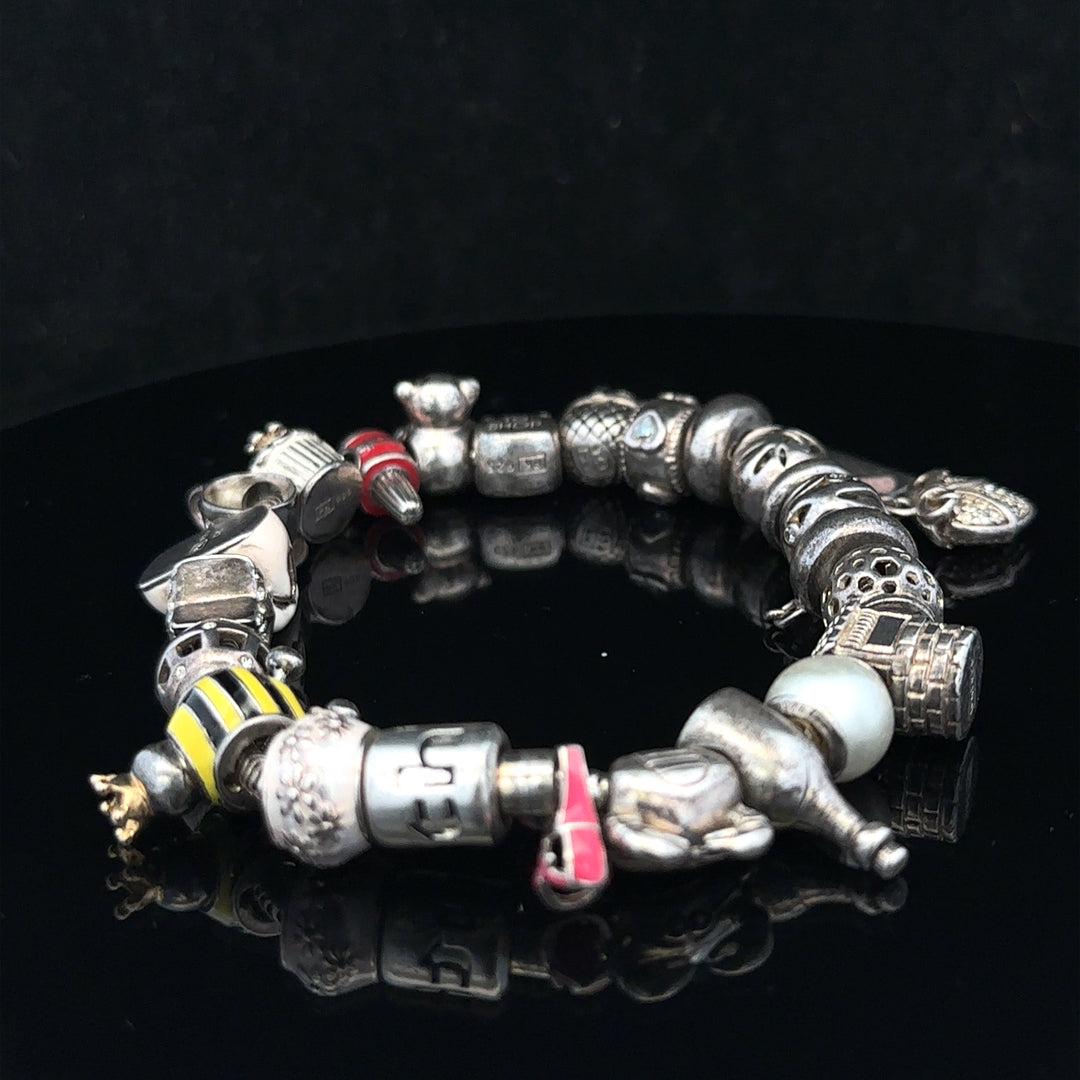 Silver charm bracelet with various decorative charms, 64.8 cm length, unbranded, stylish jewelry accessory for women