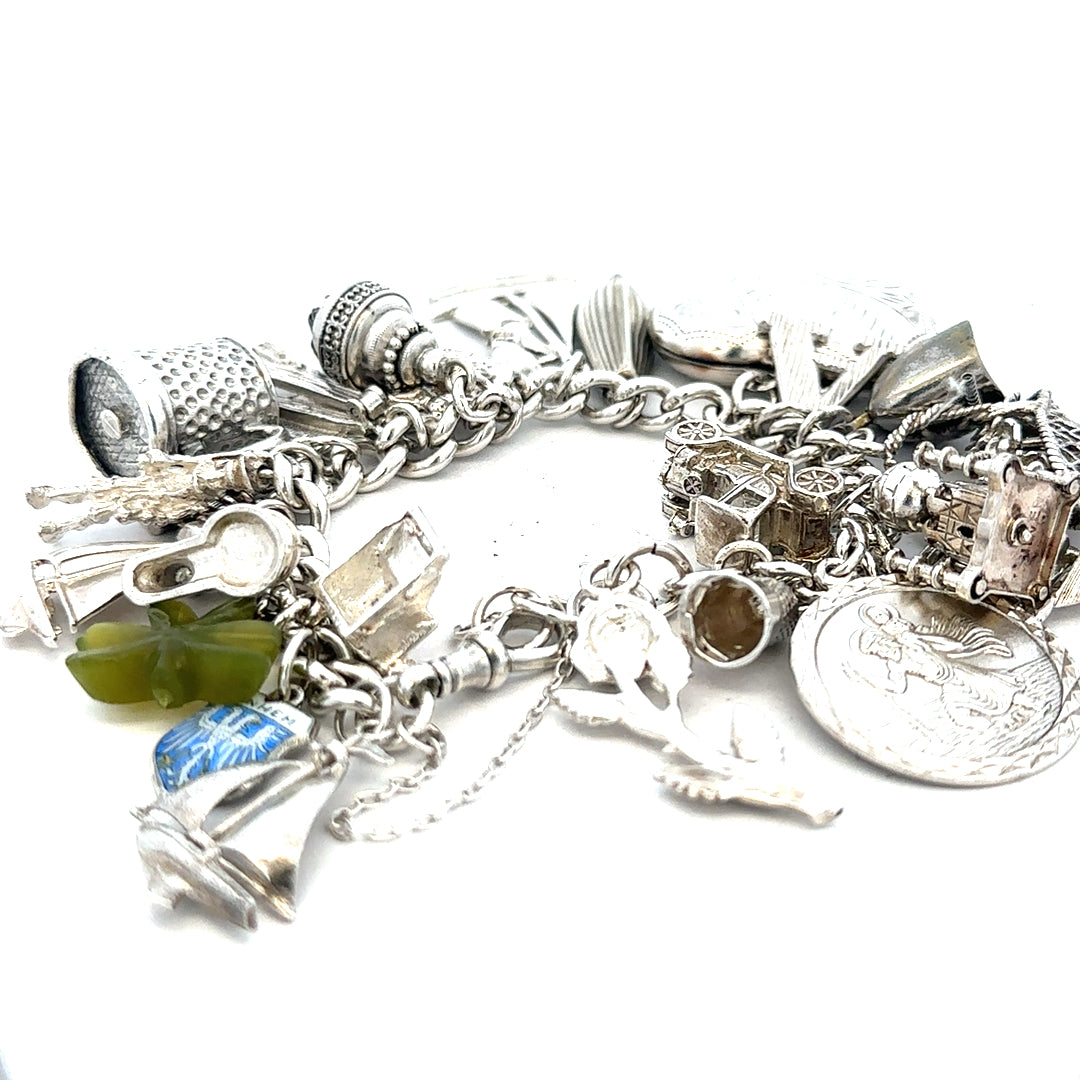 Silver charm bracelet weighing 83.4g with multiple decorative charms, crafted in sterling silver, unbranded style.