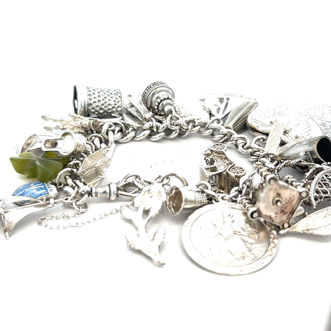 Silver charm bracelet weighing 83.4g with various decorative charms, unbranded jewelry accessory displayed on a neutral background.