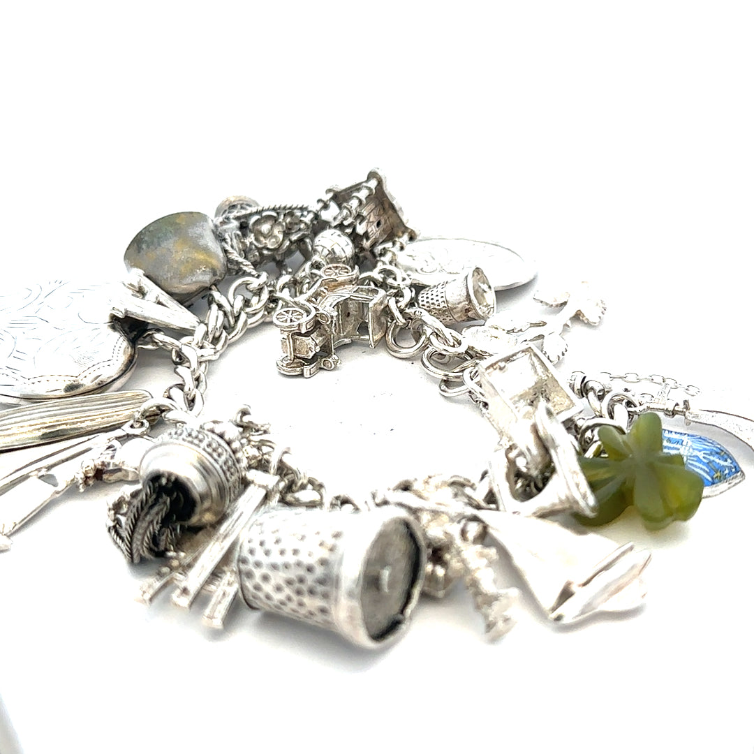 Silver charm bracelet weighing 83.4g with intricate charm details, crafted by an unbranded manufacturer.