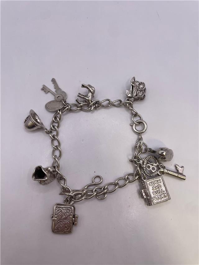Silver charm bracelet with intricate charms, weight 33.9g, showcasing detailed silver jewelry design.