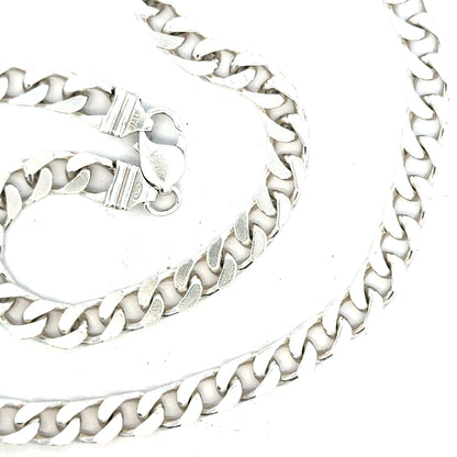 Silver curb chain weighing 63.4g, featuring a classic design with closely linked, flat, and polished silver links.