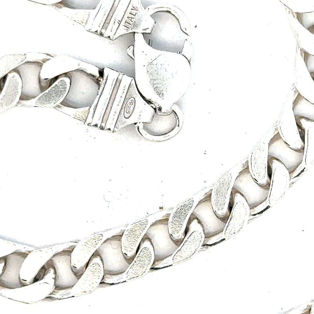 Silver curb chain weighing 63.4g, displayed on a plain background, showcasing its polished links and durable design.