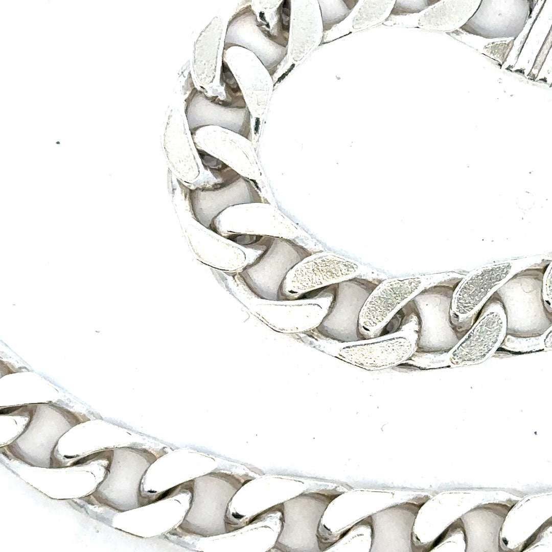 Silver curb chain weighing 63.4g with a classic design, featuring interlinked oval links, suitable for jewelry or accessories.