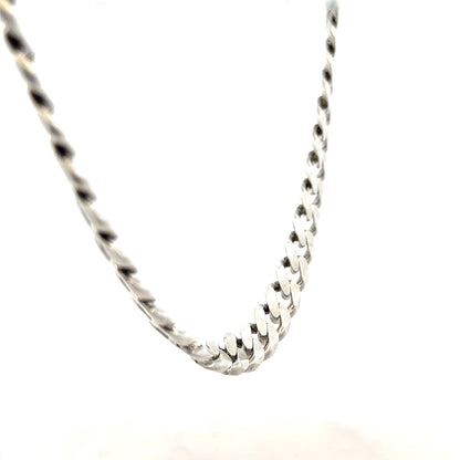 Silver curb chain weighing 94.7g, unbranded jewelry chain with interlocking links, close-up view of shiny metallic surface.