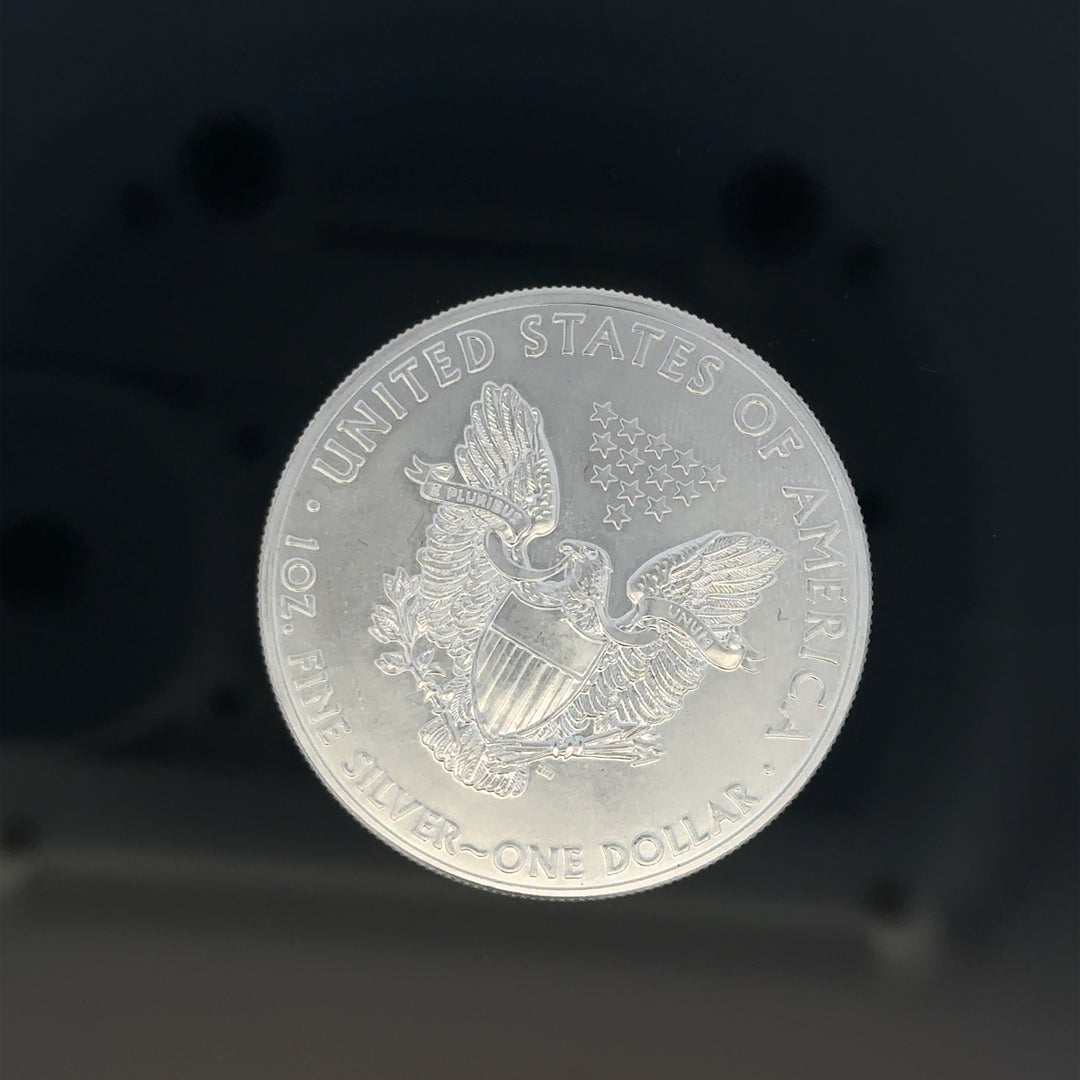 Silver one dollar coin weighing 31.2g, unbranded, featuring detailed coin design on a plain background.
