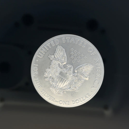 Silver one dollar coin weighing 31.2g, unbranded, featuring detailed coin design on a plain background.