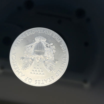 Silver one dollar coin weighing 31.2g, featuring detailed engravings and a classic design, unbranded collectible currency.