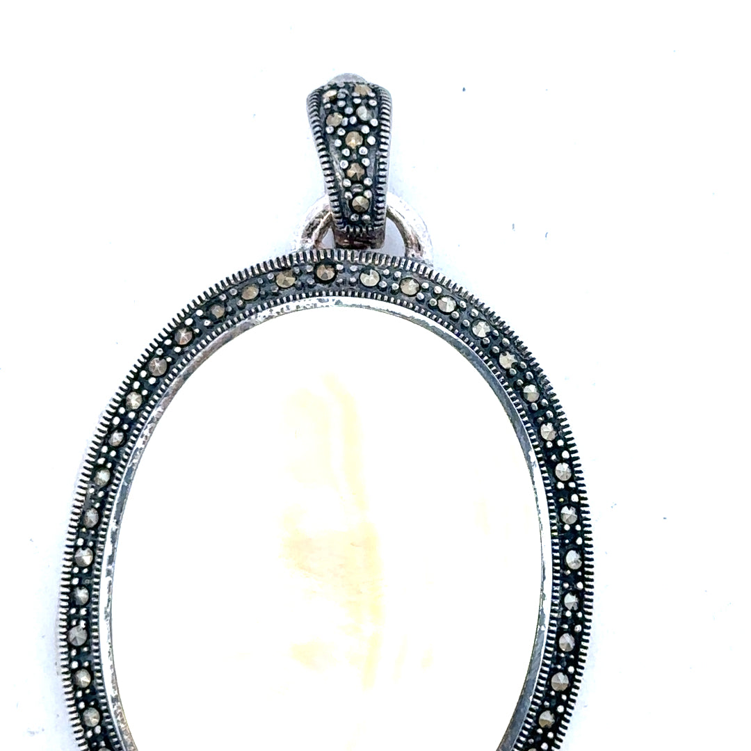 Silver pendant weighing 32.5g with intricate design, unbranded jewelry piece showcasing fine craftsmanship and polished finish.