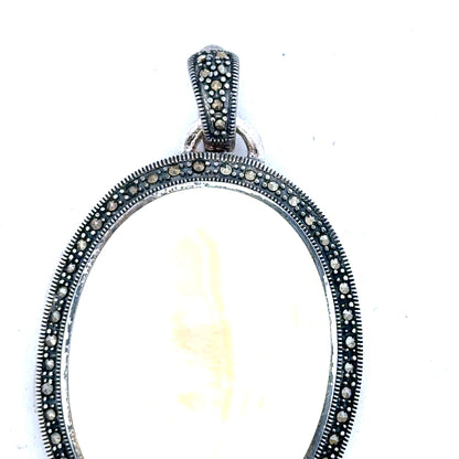 Silver pendant weighing 32.5g with intricate design, unbranded jewelry piece showcasing fine craftsmanship and polished finish.