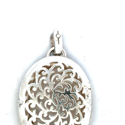 Silver pendant weighing 32.5g with intricate design, unbranded, shown resting on a plain surface in the image.