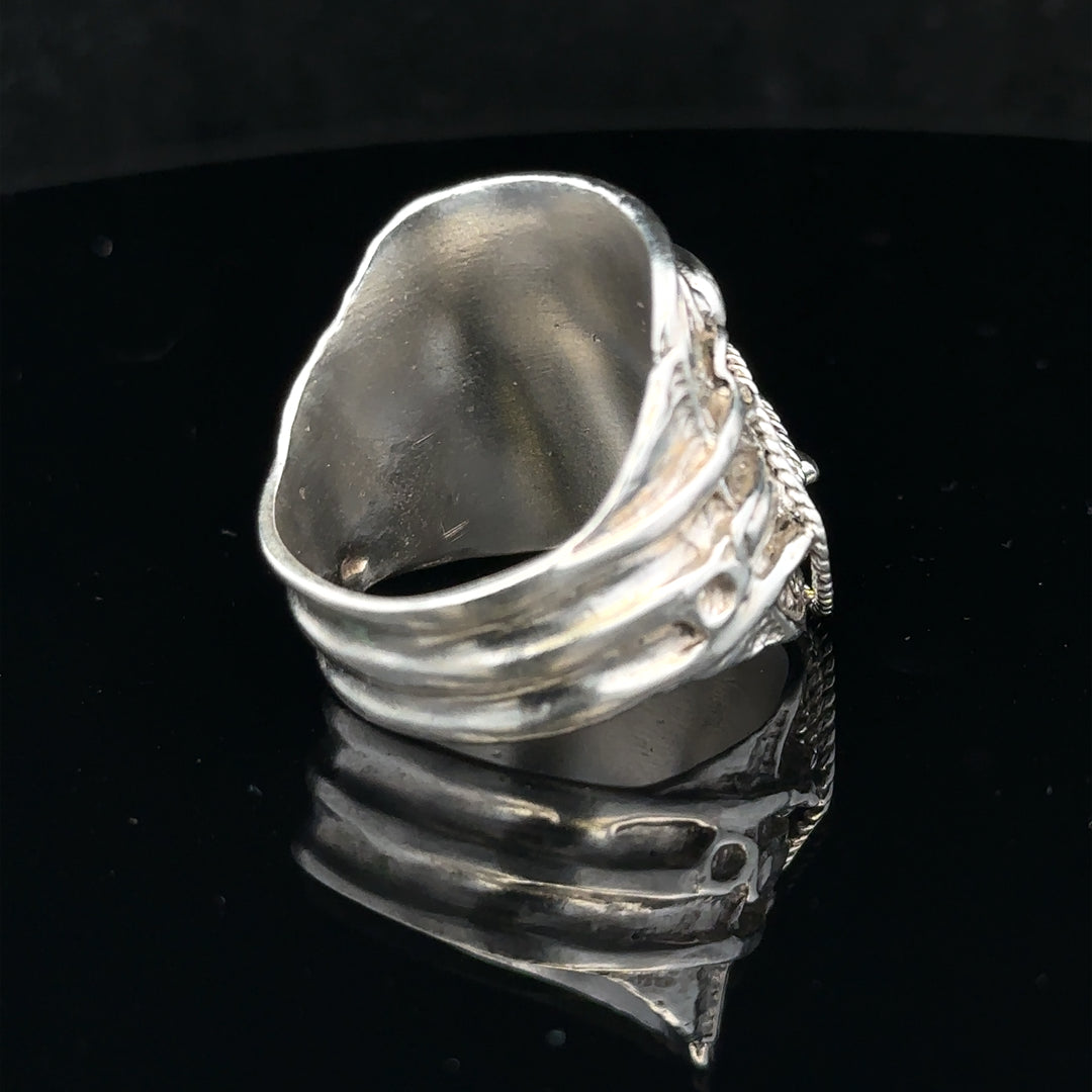 Silver saddle ring in size V with detailed design, crafted from polished silver metal.