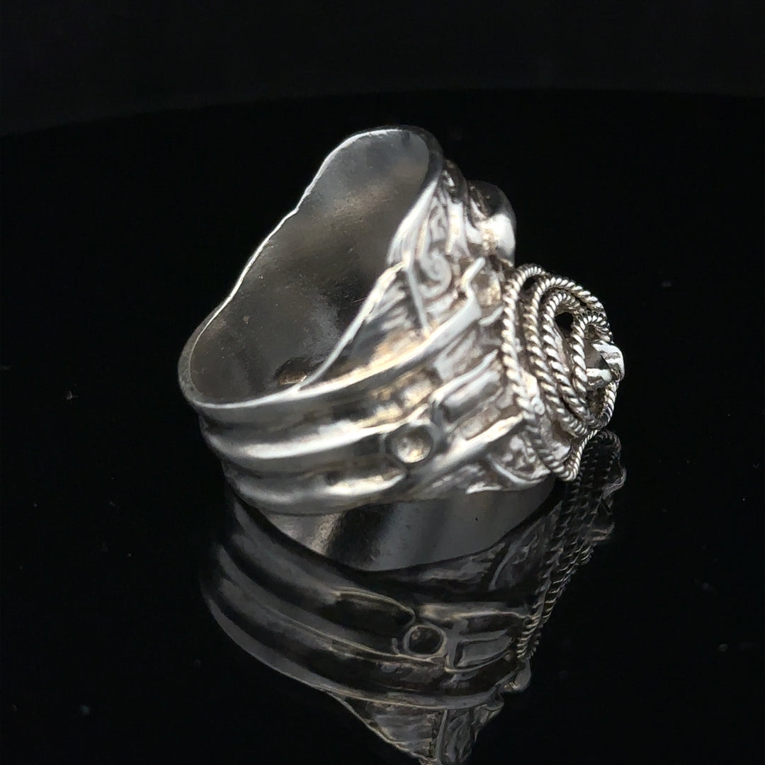 Silver saddle ring in size V, unbranded, featuring a polished silver band with a saddle-shaped design on the surface.