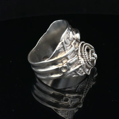 Silver saddle ring in size V, unbranded, featuring a polished silver band with a saddle-shaped design on the surface.