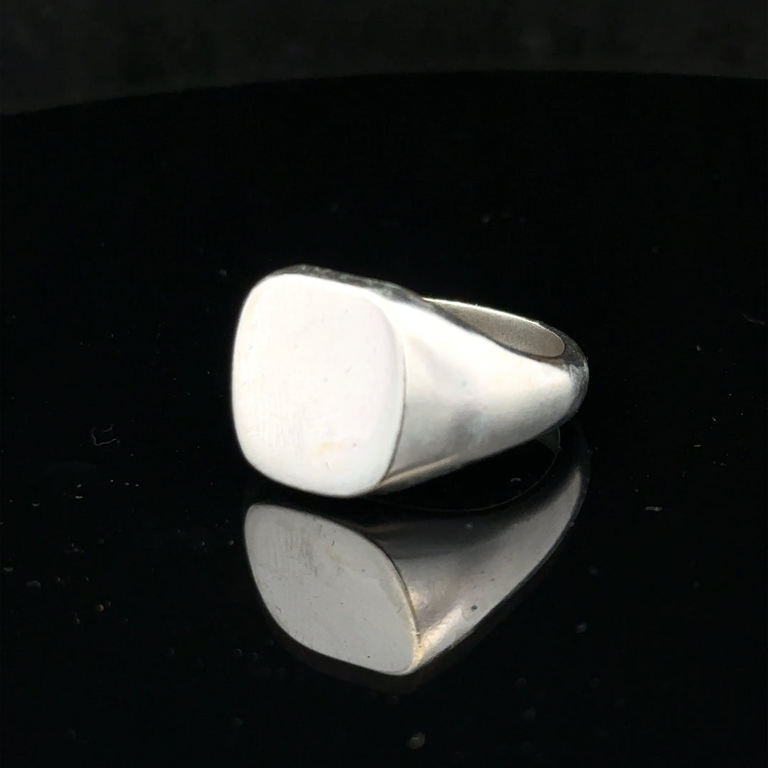 Silver signet ring in size V with a smooth, polished surface, featuring a classic design and unbranded finish.