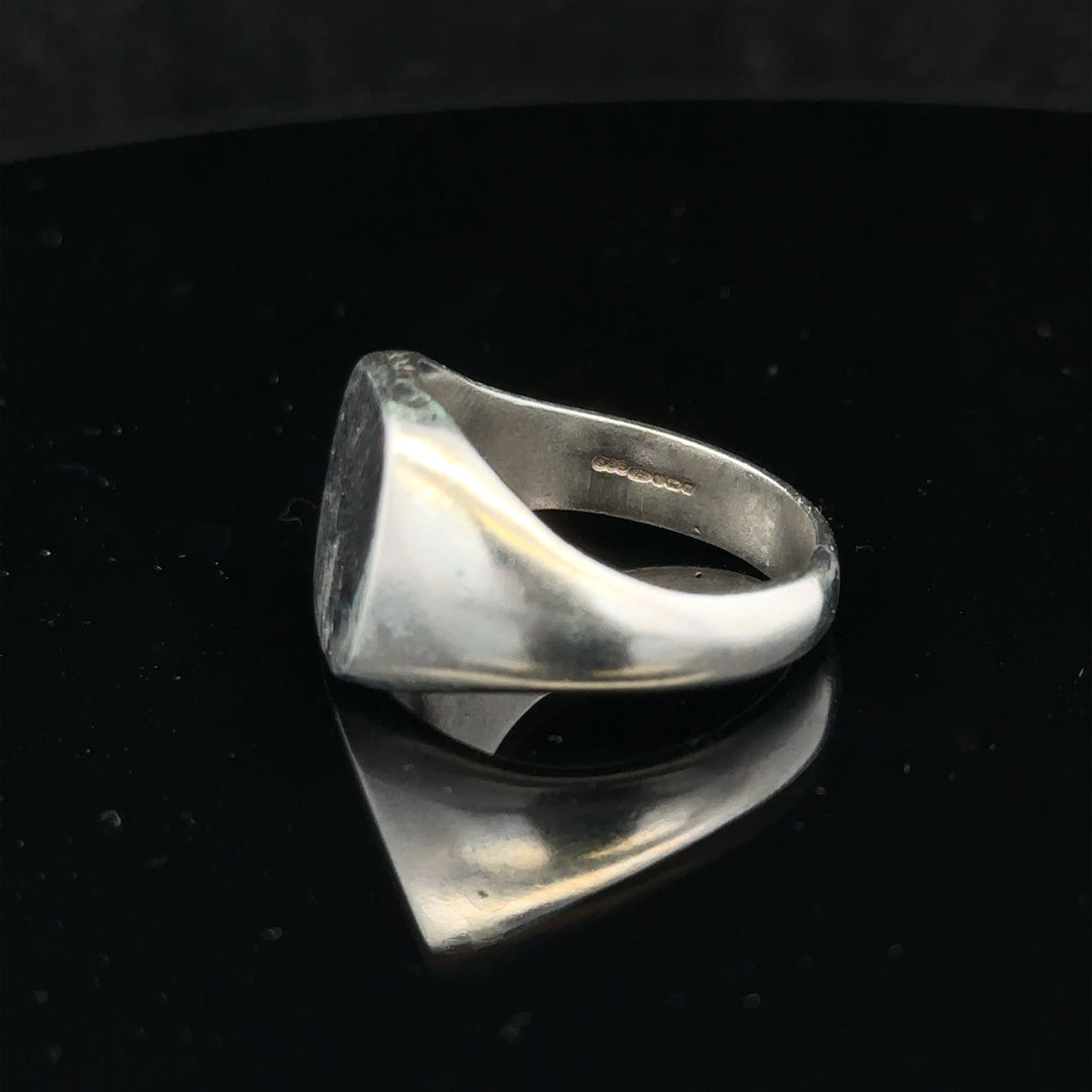 Silver signet ring size V with smooth band, unbranded, shown on a neutral background.