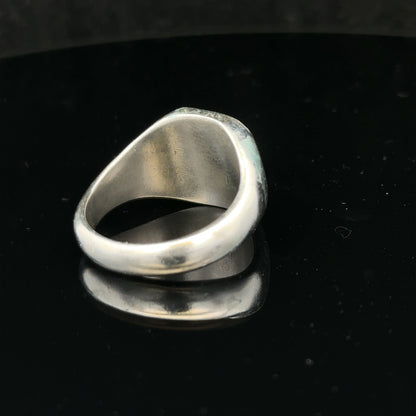 Silver signet ring in size V with engraved design, unbranded, showcasing a smooth polished surface and classic style.