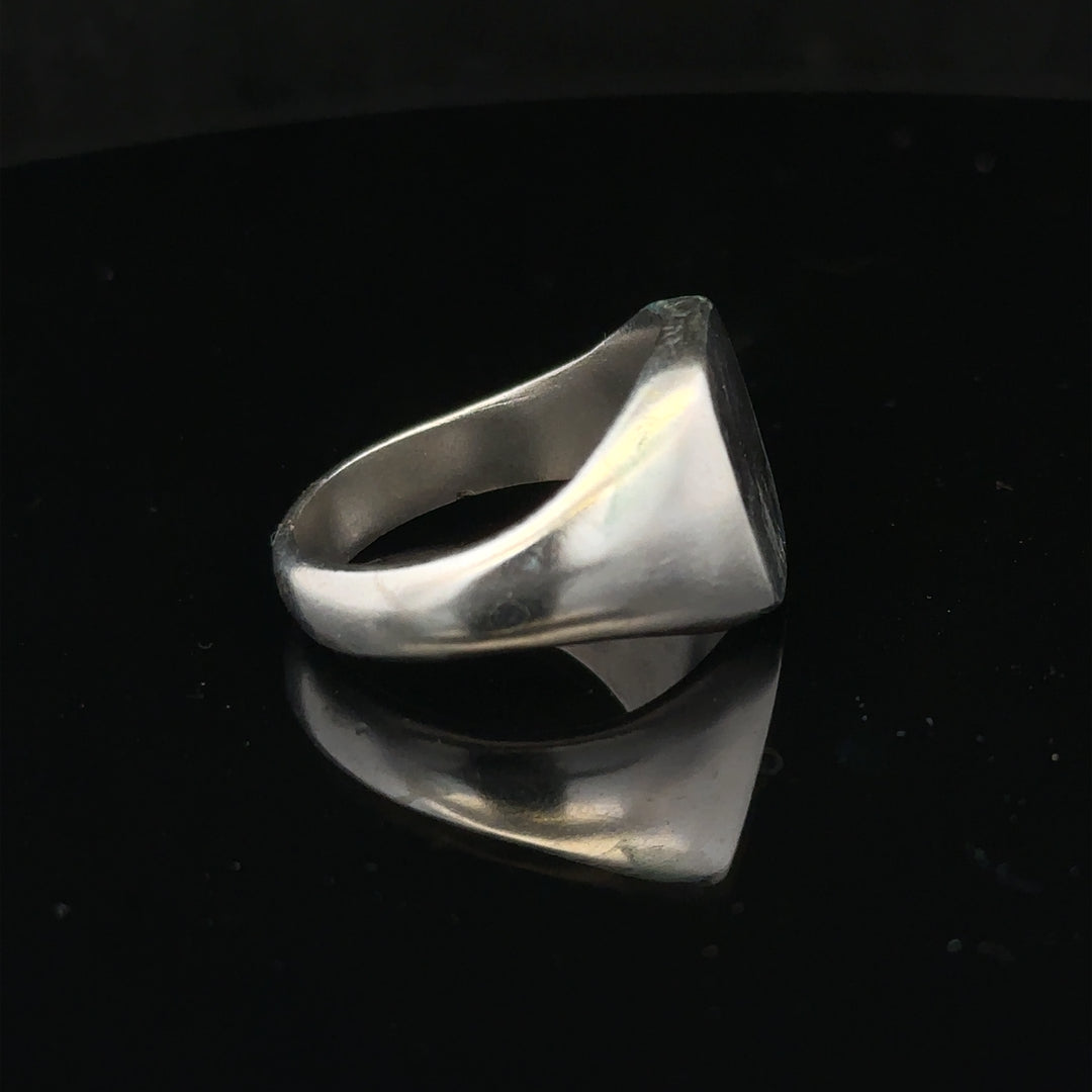 Silver signet ring in size V with a smooth band, displayed on a plain background. Unbranded jewelry accessory.
