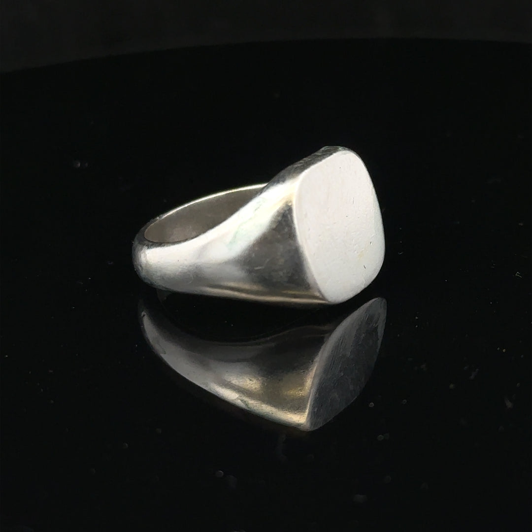 Silver signet ring in size V with a smooth band, featuring a classic design and unbranded finish.