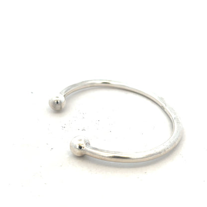 Silver torque bangle in 20g with a smooth, polished finish, featuring a classic unbranded jewelry design.