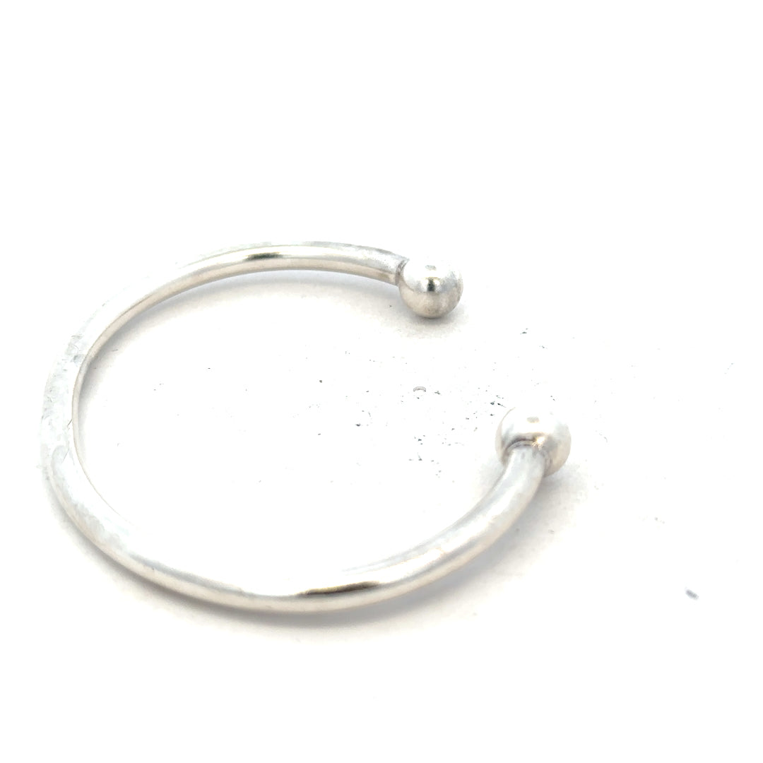 Silver torque bangle 20g, unbranded, showcasing a sleek, polished design with a smooth, rounded appearance and secure clasp.