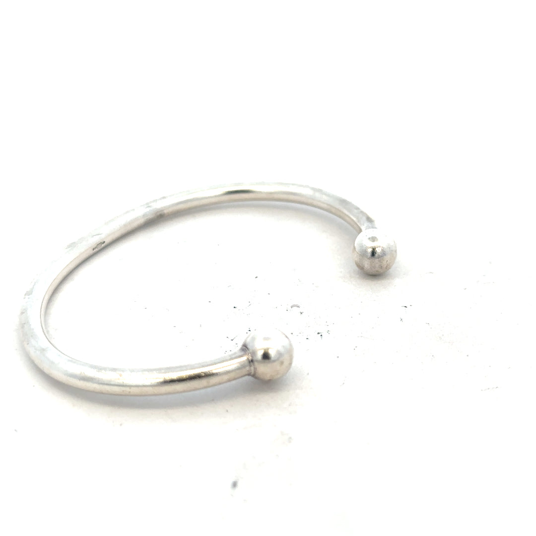 Silver torque bangle 20g, unbranded, showcasing a sleek, polished design with a smooth, rounded shape.