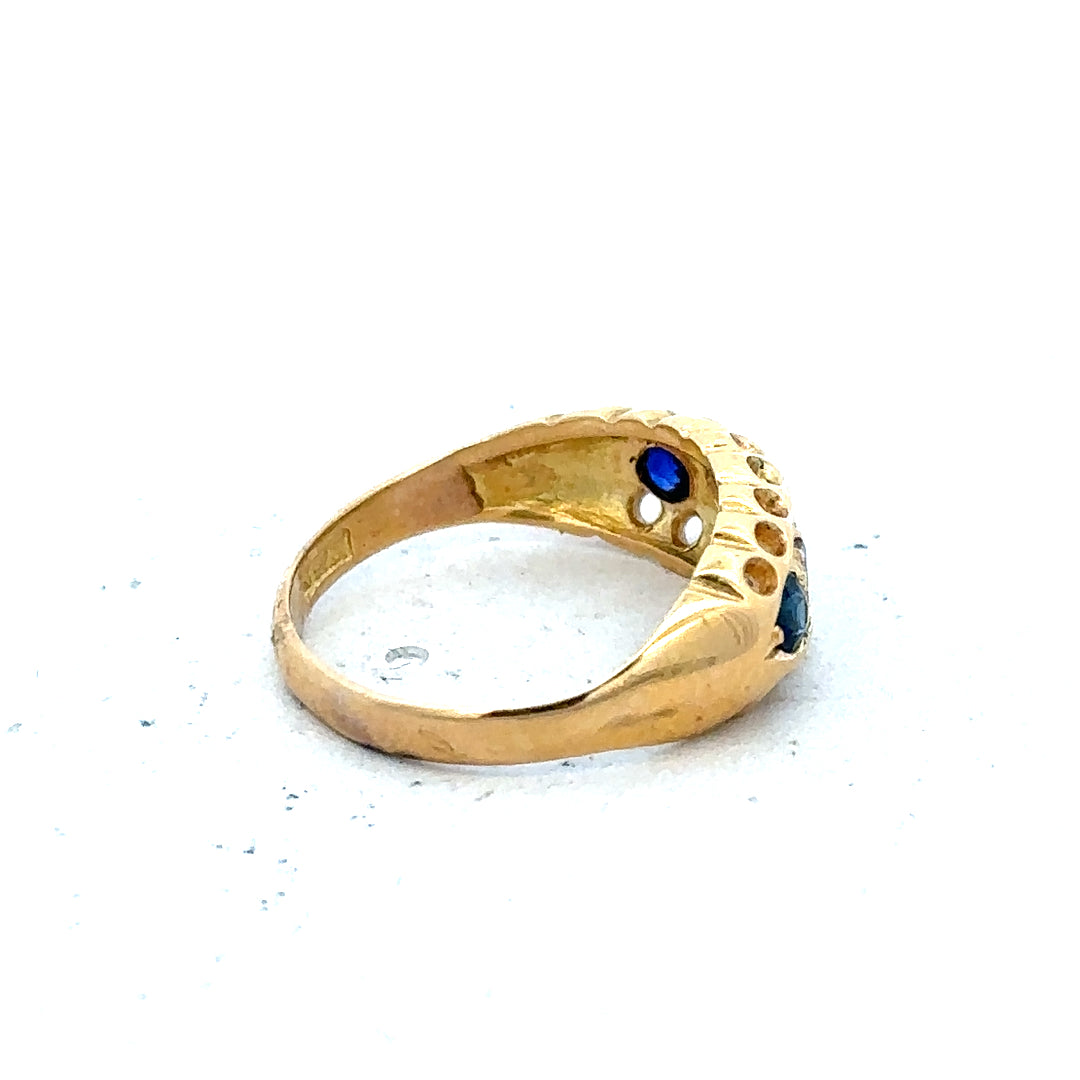 Vintage 18ct yellow gold sapphire and diamond ring with intricate design and sparkling gemstones.